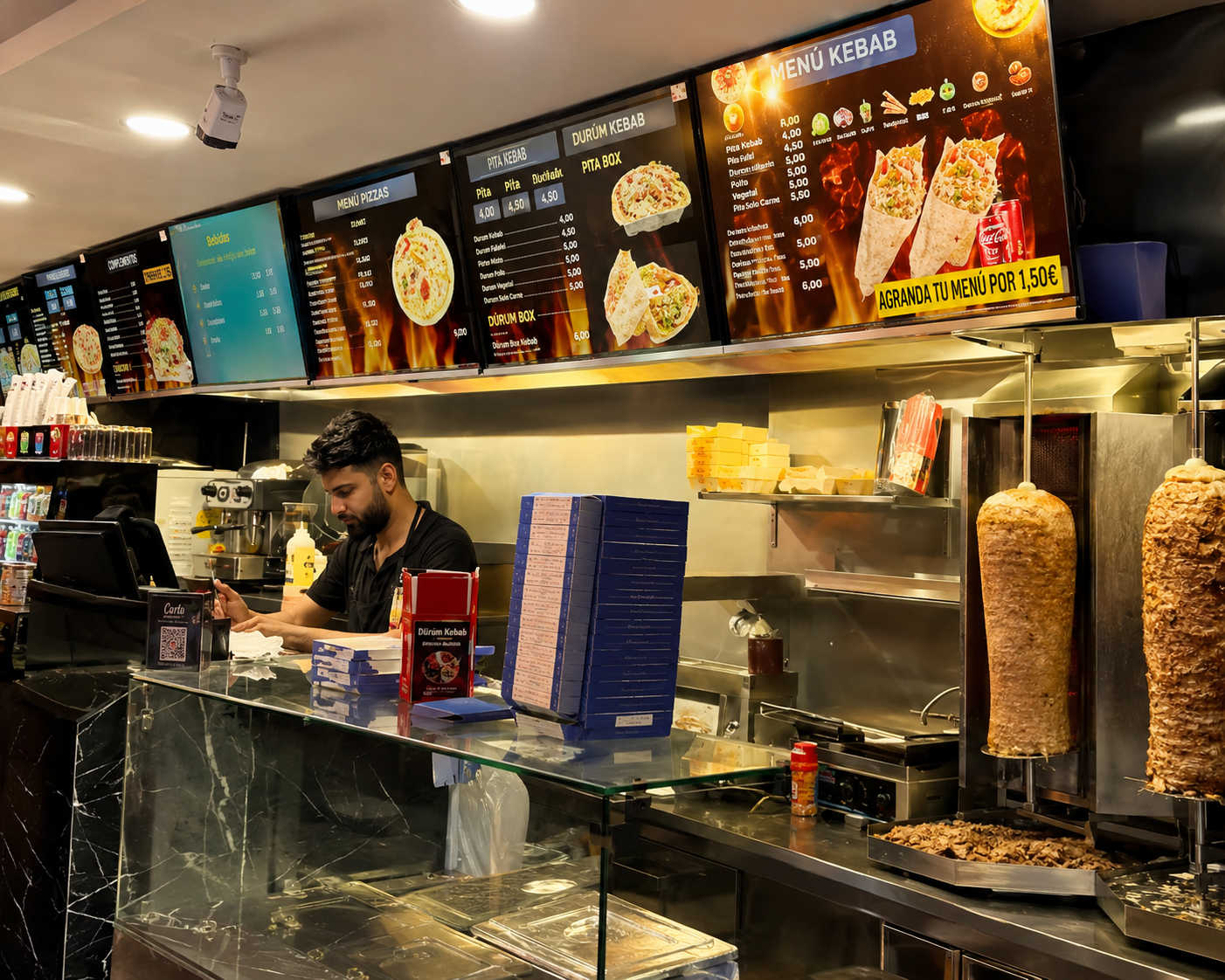 Interior de Machado Kebab: mostrador, cartas de menú y asadores de kebab